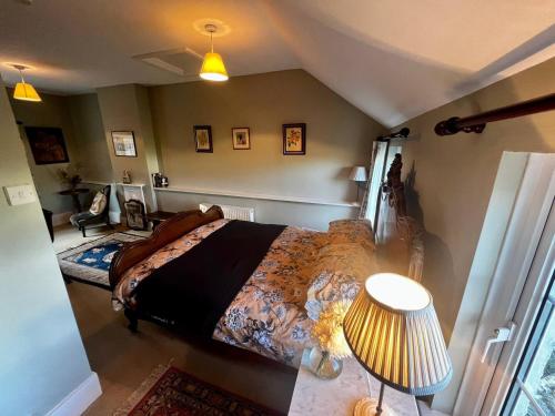 um quarto com uma cama grande e um candeeiro em 17th century cottage on farm in Vale of Glamorgan em Bonvilston