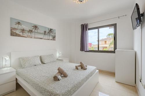 a white bedroom with a bed with two stuffed animals on it at Casa independiente con piscina privada in Adeje