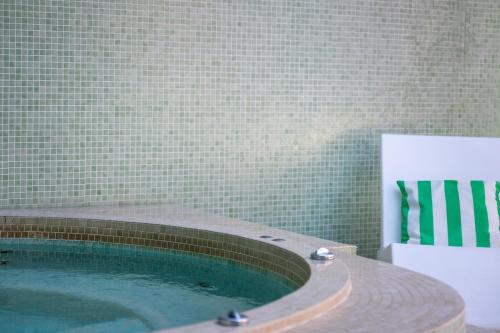 a swimming pool in a bathroom next to a tile wall at La Baignoire in Lacanau-Océan