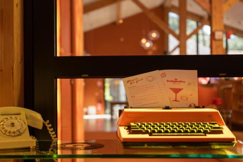 an orange computer keyboard and a phone on a table at Boutique Hôtel La Baignoire in Lacanau-Océan
