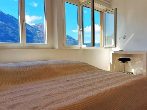 - une chambre avec un lit et une vue sur les montagnes dans l'établissement 4-Zi-WG Casa Sogno - Valle mit Kamin. Alleinlage im Rebberg!, à Agarone