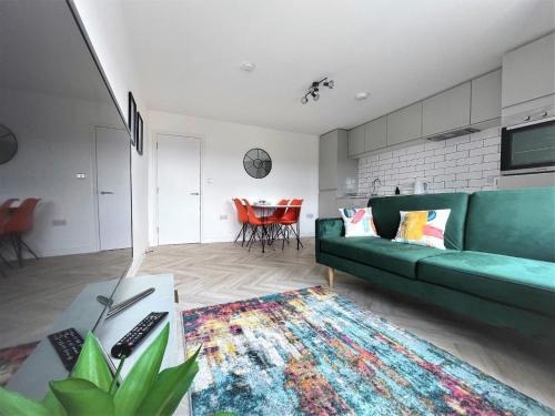 a living room with a green couch and a table at Surgery Suites in Weymouth