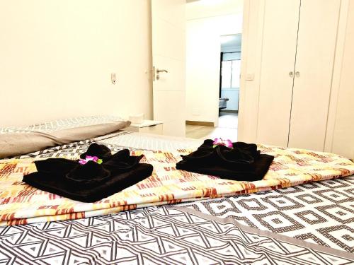 zwei schwarze Handtücher liegen auf einem Bett in der Unterkunft Jardines del Sur, 3 Bedroom in Los Cristianos