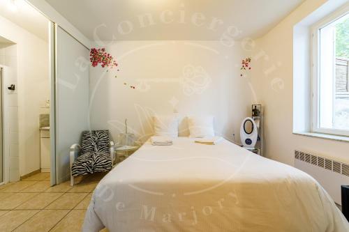 une chambre avec un lit blanc et une fenêtre dans l'établissement Le Voltaire - Escapade ensoleillée avec terrasse, à Toulon