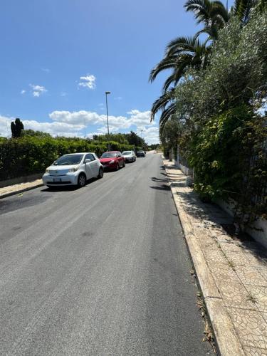 a street with cars parked on the side of the road at Apulian Way in Torre Pelosa