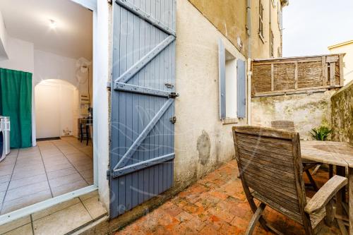 une porte ouverte menant à une chambre avec une chaise en bois dans l'établissement Le Voltaire - Escapade ensoleillée avec terrasse, à Toulon