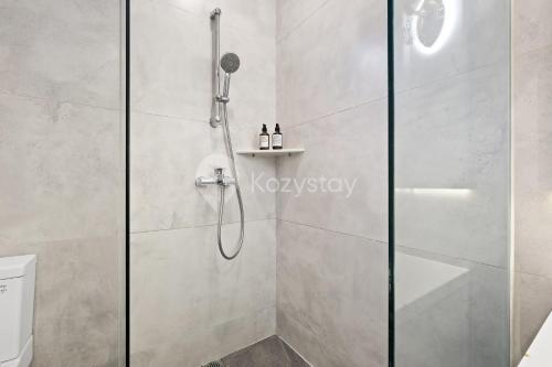 a shower with a glass door in a bathroom at Lumiere by Kozystay - Dago in Bandung