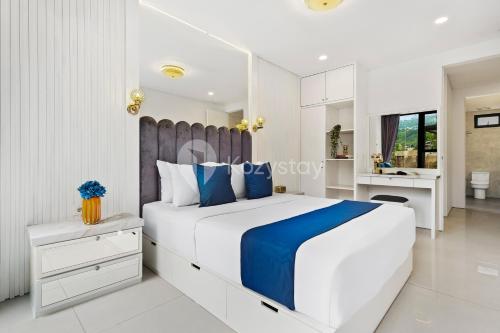 a white bedroom with a large bed and a sink at Lumiere by Kozystay - Dago in Bandung
