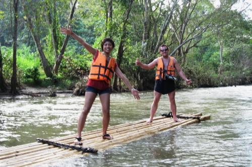 two people are standing on a raft in the water at Hello countryside in Ban Khang Hong Tai