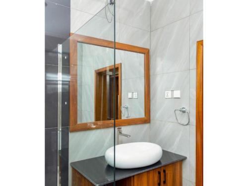 a bathroom with a sink and a mirror at Eben Lake Kivu cottages and Villas 