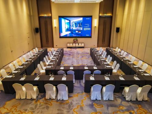 a large room with tables and chairs and a screen at Argyle Grand Hotel Nairobi Airport in Nairobi