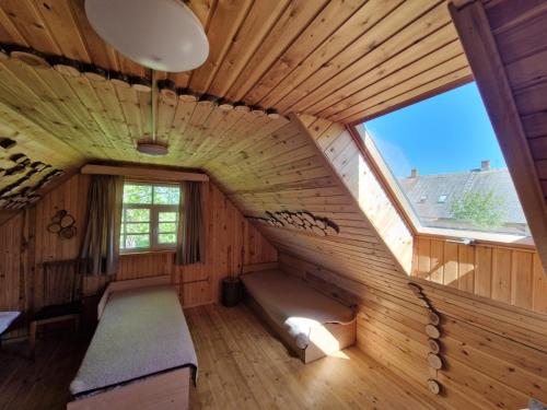 um quarto com uma escada numa casa de madeira em Bajāri - Pirts - Banya em Svente