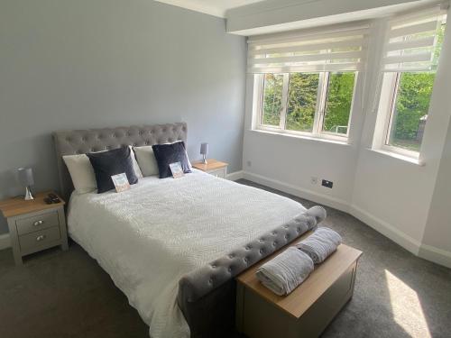 a bedroom with a large bed with two windows at LT Apartments Stoneygate - 2 Bed in Leicester