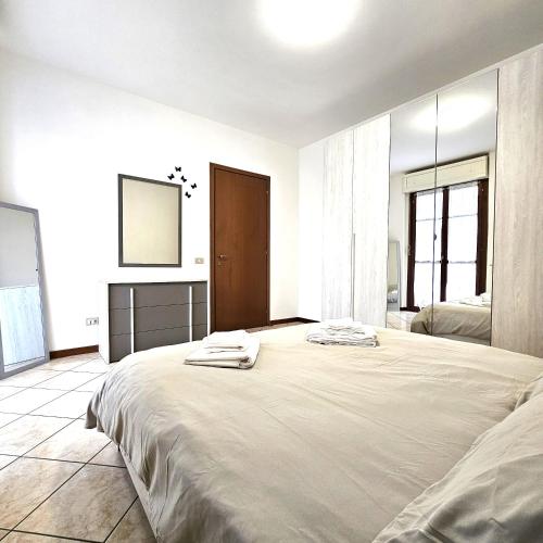 ein weißes Schlafzimmer mit einem großen Bett mit Handtüchern darauf in der Unterkunft Appartamento Moderno Gallarate in Gallarate