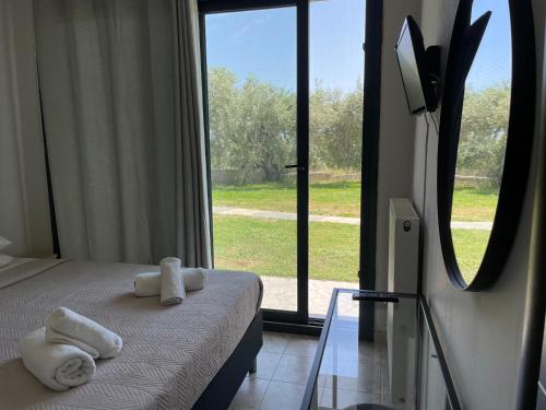 リメナリアにあるDiscovery Villasの大きな窓のあるベッドの上にタオルが備わるベッドルーム1室が備わります。