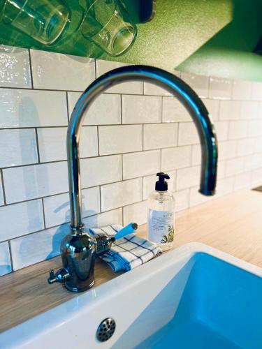 a kitchen sink with a faucet and a bottle of soap at Cozy countryside retreat near Söderåsen National Park in Svenstorp