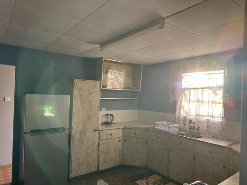 a kitchen with a refrigerator and a window at Moravian Haven in Christ Church