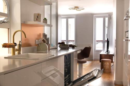 une cuisine avec un évier et un comptoir dans l'établissement La Harmonie Eiffel - Walk to Tower, à Paris