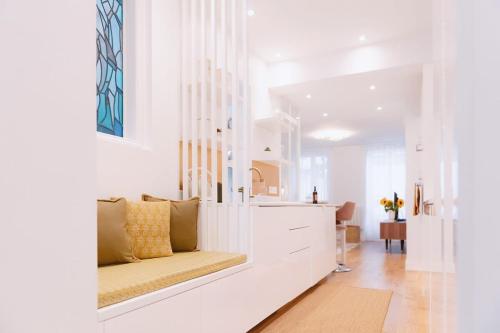 - un salon blanc avec un banc dans une pièce dans l'établissement La Harmonie Eiffel - Walk to Tower, à Paris