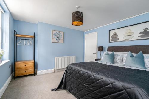 een slaapkamer met blauwe muren en een groot bed bij Central-Few Steps from Brighton Beach by Creatick in Brighton & Hove