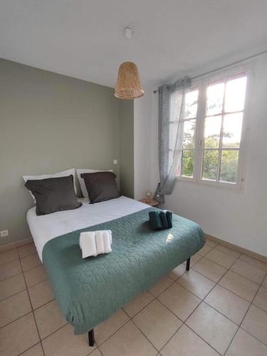 une chambre avec un grand lit avec deux serviettes dessus dans l'établissement Arcachon Appartement 4 personnes - Résidence Beauséjour, à Arcachon