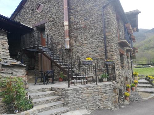 a stone house with stairs and a patio at Apartamento Forn de Serra in Lladorre
