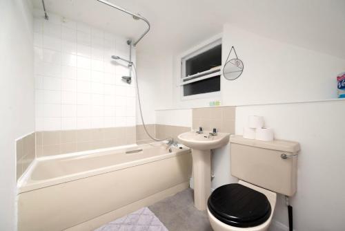 a bathroom with a sink and a toilet and a bath tub at Spacious minimalist 1BR flat in London in London