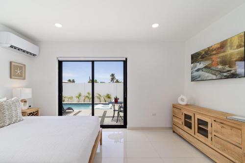 a bedroom with a bed and a view of a pool at Tanki Leendert 43K in Oranjestad