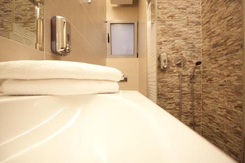a bathroom with a tub and a shower with towels at X Dream Hotel-Adults Only in Athens