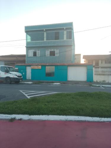 un bâtiment avec une camionnette garée dans un parking dans l'établissement Pousada pés na areia, à Serra