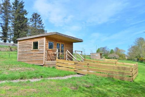 a wooden cabin in a field with a fence at Anniston Mill Cabin 1 in Arbroath