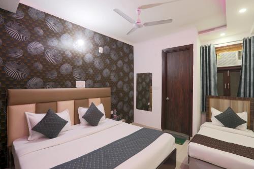 a bedroom with two beds and a wall mural at Hotel Red Velvet suites in New Delhi