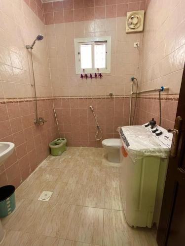 Baño de color rosa con aseo y lavamanos en شقة مفروشة حي الصفا, en Al Wajh