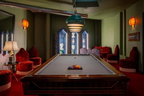 a pool table in a room with red chairs at Hotel Number Nine in Florence