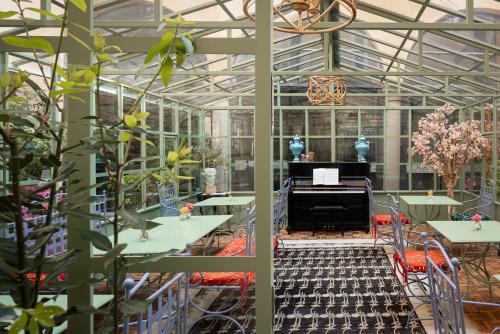 a greenhouse with tables and a piano in it at Hotel Number Nine in Florence