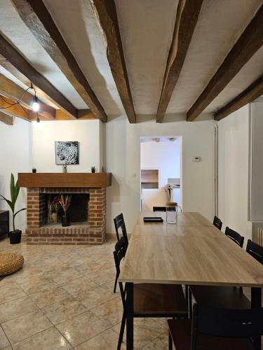 une salle à manger avec une table et une cheminée dans l'établissement Maison Ed'Or - 10 Min de beauval, à Orbigny