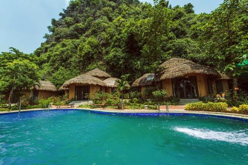 a resort with a swimming pool in front of a mountain at Trang An Legend in Ninh Binh