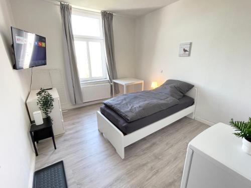 5-Zimmer Apartment in Osnabrück في أوسنابروك: غرفة نوم بسرير وتلفزيون بشاشة مسطحة