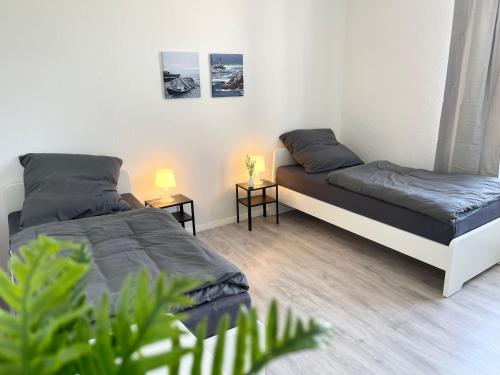5-Zimmer Apartment in Osnabrück في أوسنابروك: سريرين في غرفة صغيرة مع طاولتين