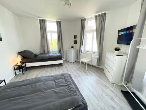 5-Zimmer Apartment in Osnabrück في أوسنابروك: غرفة نوم فيها سرير وتلفزيون