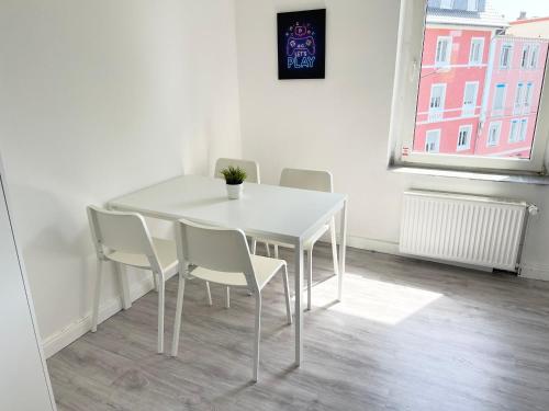 5-Zimmer Apartment in Osnabrück في أوسنابروك: طاولة بيضاء وكراسي في غرفة مع نافذة