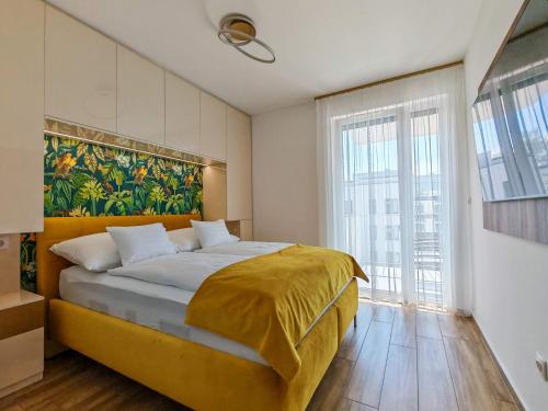 a bedroom with a large bed with a painting on the wall at AquaSuite Budapest in Budapest
