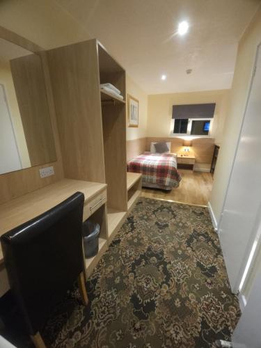 a hotel room with a bed and a desk and a chair at The Abbey House Hotel in Reading