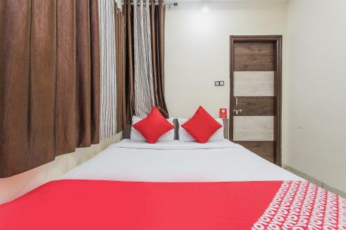 una camera da letto con un grande letto con cuscini rossi di Hotel Mehar Residency a Indore
