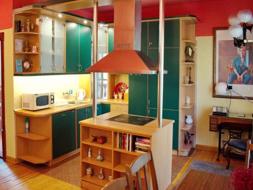 une cuisine avec des placards verts et un comptoir avec un four micro-ondes dans l'établissement Marilyn Apartments, à Smederevo