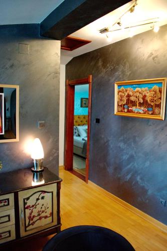 a room with a lamp on a table and a bedroom at Marilyn Apartments in Smederevo