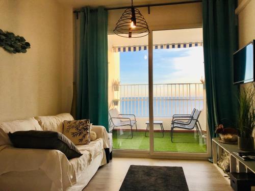 un soggiorno con divano e vista sull'oceano di Apartamento Cloe con terraza y vistas al Mar a El Puerto de Santa María