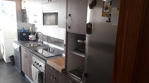 a kitchen with a stainless steel refrigerator and a sink at Fantástico apartamento en la playa san Juan in Alicante
