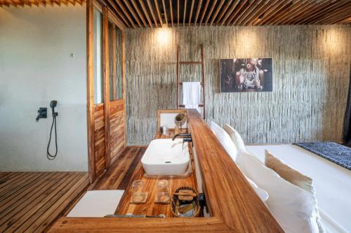 um quarto com uma cama com um lavatório em Bamboo Zanzibar em Jambiani