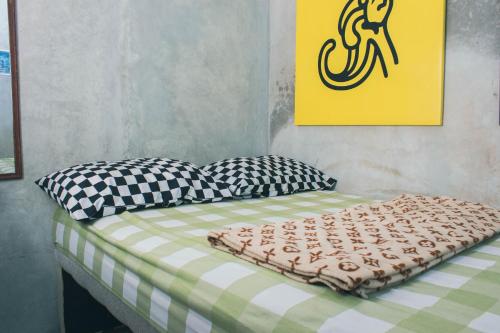 a bed with two pillows on it in a room at Condro Wulan Hostel in Malang